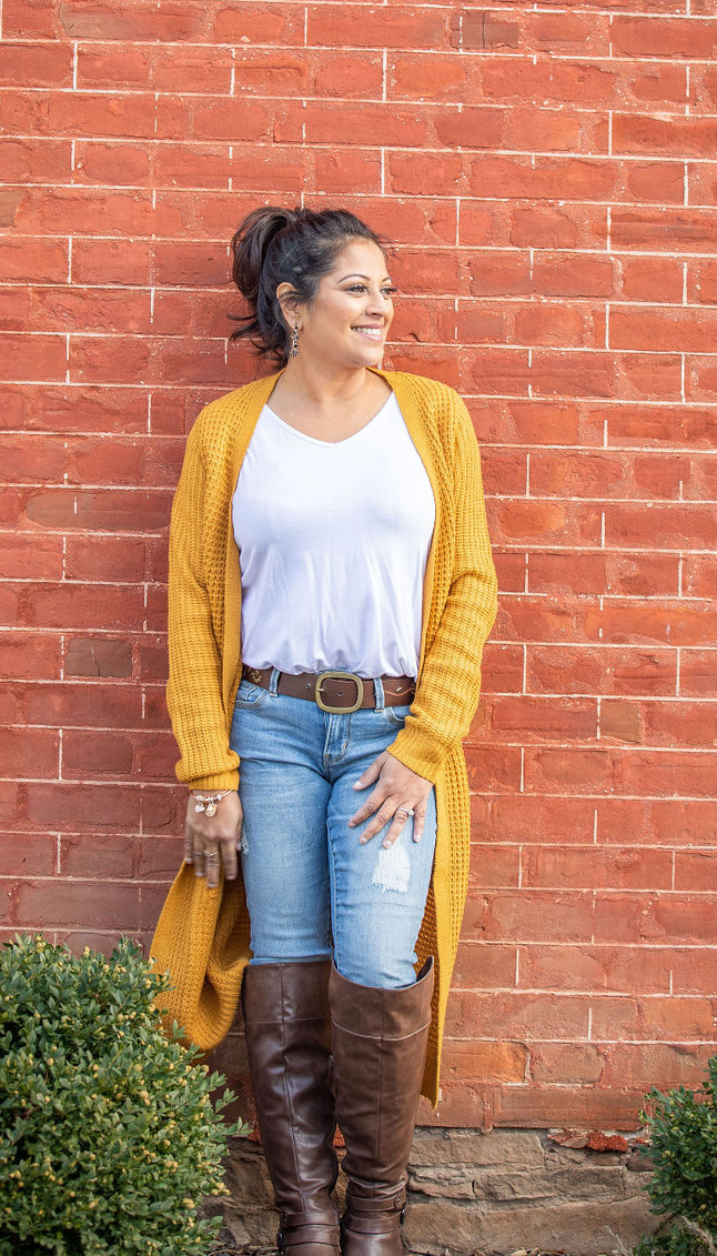 Beena Guide standing against a brick wall